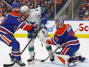 L'attaquant Brock Boeser (6) affronte les défenseurs des Oilers d'Edmonton Darnell Nurse devant le gardien Stuart Skinner.