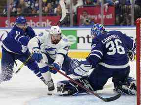 L'ailier gauche du Lightning de Tampa Bay, Nicholas Paul, tombe face au gardien de but des Maple Leafs de Toronto, Jack Campbell, tandis que le centre des Maple Leafs, Colin Blackwell, défend lors de la troisième période de la série éliminatoire de premier tour de la LNH à Toronto, le samedi 14 mai 2022.