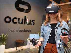 Dans cette photo d'archive prise le 23 octobre 2019, Elza Uzmanoff, employée de Facebook, essaie un appareil Oculus sur le campus du siège social de l'entreprise à Menlo Park, en Californie.