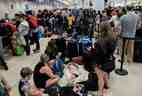 Les passagers des compagnies aériennes Sunwing font la queue pour l'enregistrement à l'aéroport international de Cancun après que de nombreux vols vers le Canada ont été annulés en raison des conditions météorologiques hivernales rigoureuses dans diverses régions du pays, à Cancun, au Mexique, le 27 décembre 2022.