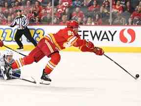 L'attaquant des Flames de Calgary Blake Coleman (20 ans) tend la main contre le défenseur des Canucks de Vancouver Quinn Hughes (43 ans) en troisième période au Scotiabank Saddledome de Calgary le 31 décembre 2022.