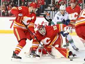 Le gardien des Flames de Calgary Jacob Markstrom (25 ans) arrête un tir contre les Canucks de Vancouver au cours de la deuxième période au Scotiabank Saddledome de Calgary le 31 décembre 2022.