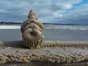 Un gnome émerge du lac Érié le 27 décembre 2022, après que des vents violents et de l'eau du lac pulvérisée aient créé de superbes sculptures gelées le long de la jetée de Port Stanley.  Cette figure a été formée sur un lampadaire.