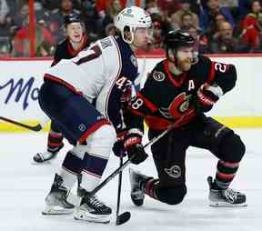 L'ailier droit des Sénateurs d'Ottawa Claude Giroux et le défenseur des Blue Jackets de Columbus Marcus Bjork suivent le jeu en troisième période.