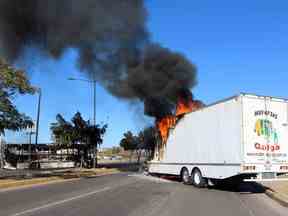 L'épave brûlée d'un bus et d'un camion en feu, incendiés par des membres d'un gang de drogue, est photographiée à la suite de l'arrestation du chef d'un gang de drogue mexicain Ovidio Guzman, fils du caïd incarcéré Joaquin 