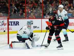 L'ailier gauche des Sénateurs d'Ottawa Tim Stutzle (18 ans) marque son troisième but du match contre le gardien de Seattle Kraken Martin Jones (30 ans) lors d'un match de troisième période dans la LNH au Centre Canadian Tire le samedi 7 janvier 2023.