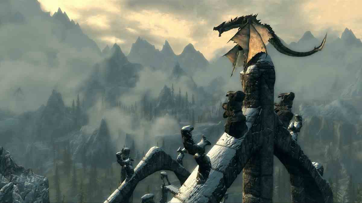 Skyrim - un dragon perché sur une spirale de château rugit de manière menaçante.  Au loin, les montagnes et le ciel.