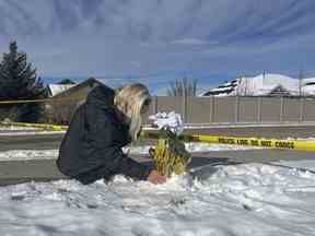 Sharon Huntsman, membre de l'Église de Jésus-Christ des Saints des Derniers Jours de Cedar City, Utah, laisse des fleurs devant une maison où huit membres de la famille ont été retrouvés morts à Enoch, Utah, le jeudi 5 janvier 2023.