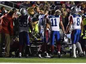 Le personnel d'entraînement s'occupe de Jonathan Hefney des Alouettes de Montréal lors de la première moitié d'un match de la LCF 2015 contre le Rouge et Noir d'Ottawa à Ottawa.