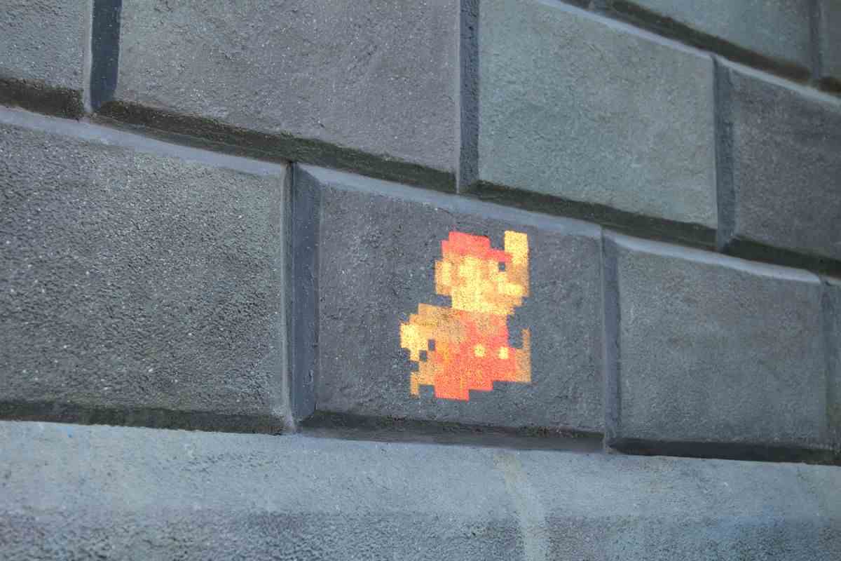 Une projection de Mario pixélisé sur fond de mur de briques.
