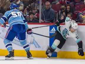 David Savard des Canadiens renverse Jared McCann des Seattle Kraken lors de la deuxième période d'un match de la Ligue nationale de hockey à Montréal le lundi 9 janvier 2023.