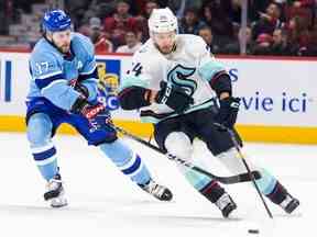 Josh Anderson des Canadiens met en échec avant Jamie Oleksiak de Seattle Kraken lors de la première période d'un match de la Ligue nationale de hockey à Montréal le lundi 9 janvier 2023.