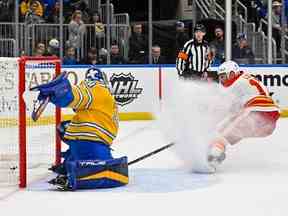 L'attaquant des Flames de Calgary, Milan Lucic, marque contre le gardien des Blues de St. Louis, Jordan Binnington, au Enterprise Center de St. Louis, le mardi 10 janvier 2023.