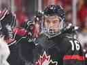 Connor Bedard célèbre son but avec ses coéquipiers sur le banc lors de la première période contre l'équipe de la Slovaquie en quarts de finale du Championnat mondial junior 2023 de l'IIHF le 2 janvier.