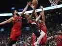 Le garde des Portland Trail Blazers Gary Payton II (0) va au panier alors que le garde des Raptors de Toronto Fred VanVleet (23) et l'attaquant Scottie Barnes (4) défendent au cours de la seconde moitié à la Scotiabank Arena. 