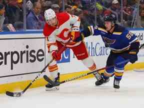 Walker Duehr des Flames de Calgary cherche à passer la rondelle contre Noel Acciari des Blues de St. Louis en troisième période au Enterprise Center le 12 janvier 2023 à St Louis, Missouri.