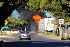 Un véhicule est vu près d'autobus en flammes qui ont été incendiés par des membres d'un gang de trafiquants de drogue à la suite de la détention du chef de gang mexicain Ovidio Guzman, fils du caïd incarcéré Joaquin 