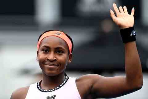 coco gauff sourit et salue après avoir remporté un match de tennis