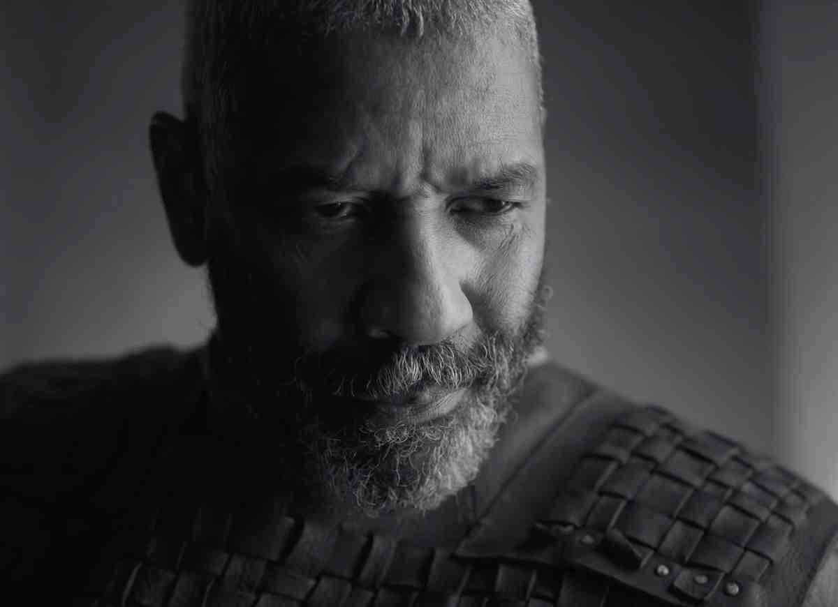 Denzel Washington souriant comme Macbeth dans La Tragédie de Macbeth