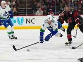 Le centre des Hurricanes de la Caroline Derek Stepan (21) voyage le centre des Canucks de Vancouver JT Miller (9) au cours de la deuxième période au PNC Arena.