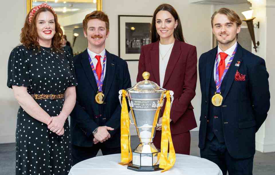 La britannique Catherine, princesse de Galles (2R) se tient avec l'anglais James Simpson (2L), l'entraîneur-chef de l'Angleterre Tom Cold (R) et Josie Hill, alors qu'ils posent avec le trophée de la Coupe du monde de rugby à XIII, pendant une réception en reconnaissance du succès de l'équipe de la Ligue anglaise de rugby en fauteuil roulant lors de la récente Coupe du monde de rugby, au palais de Hampton Court, dans le sud-ouest de Londres, le 19 janvier 2023. (Photo de Mark Large / POOL / AFP) (Photo de MARK LARGE /POOL/AFP via Getty Images)