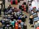 Les sacs à bagages sont amassés dans la zone de récupération des bagages de l'aéroport international Pearson de Toronto, alors qu'une importante tempête hivernale perturbe les vols à destination et en provenance de l'aéroport, à Toronto, le 24 décembre 2022.