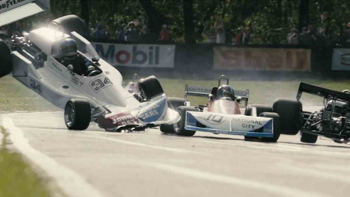 Une voiture de course roule le long de la courbe d'une piste de course alors qu'une voiture de course adjacente s'écrase à côté.