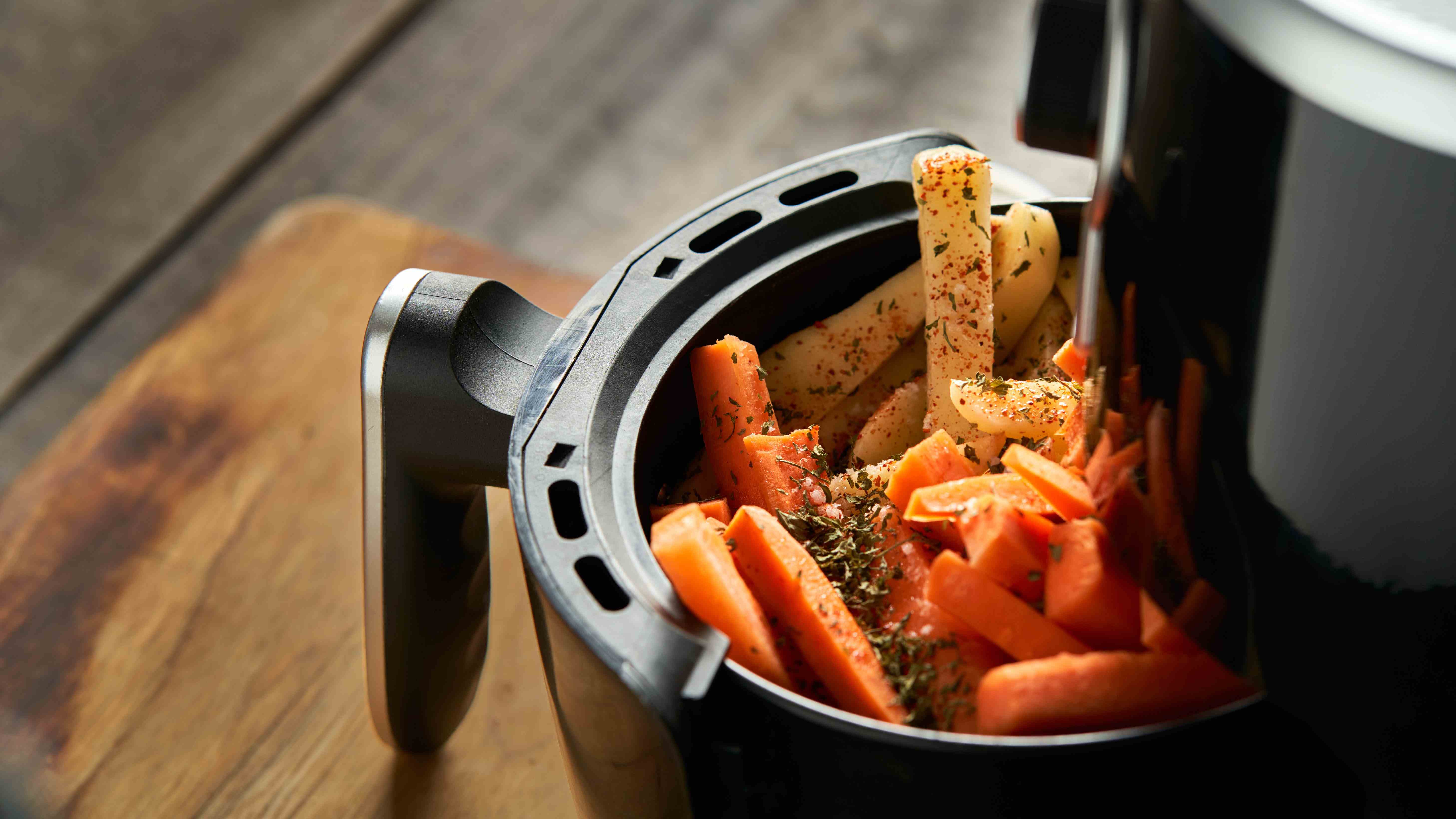 Une friteuse à air remplie de légumes assaisonnés