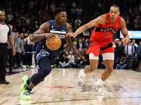 19 janvier 2023 ;  Minneapolis, Minnesota, États-Unis ;  Le garde des Timberwolves du Minnesota Anthony Edwards (1) dribble tandis que l'attaquant des Raptors de Toronto Scottie Barnes (4) défend au cours du quatrième quart au Target Center.