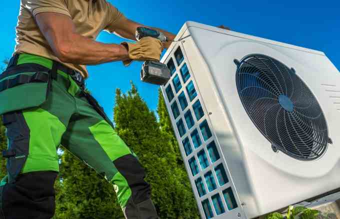 Technicien CVC installant une grande pompe à chaleur moderne