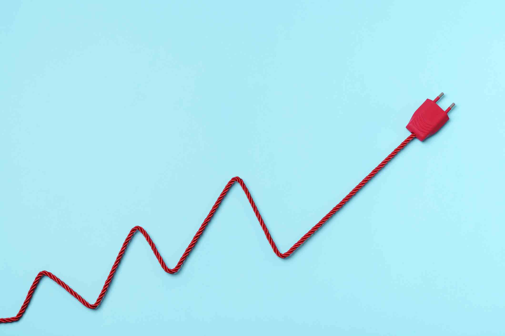 Fiche d'alimentation électrique rouge et câble formant un graphique sur fond bleu.  tarification basée sur l'utilisation