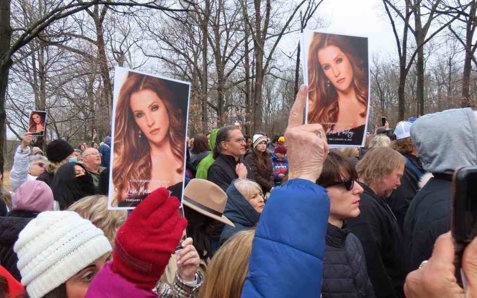 Des membres du public brandissent des photos de Lisa Marie Preseley à Graceland