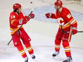 Les Flames de Calgary Johnny Gaudreau et Trevor Lewis célèbrent le but vide de Lewis menant à une victoire de 3-1 contre les Stars de Dallas dans le cinquième match des séries éliminatoires de la Coupe Stanley à Calgary le mercredi 11 mai 2022.