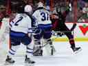 Le centre des Sénateurs d'Ottawa Josh Norris (9) se fait trébucher par le gardien de but des Jets de Winnipeg Connor Hellebuyck (37) lors de la première période d'action de la LNH au Centre Canadian Tire le samedi 21 janvier 2023. ERROL MCGIHON/Postmedia.