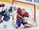 Le gardien de but des Canadiens de Montréal Sam Montembeault arrête les Maple Leafs de Toronto John Tavares alors que les Canadiens David Savard défendent en première période samedi.