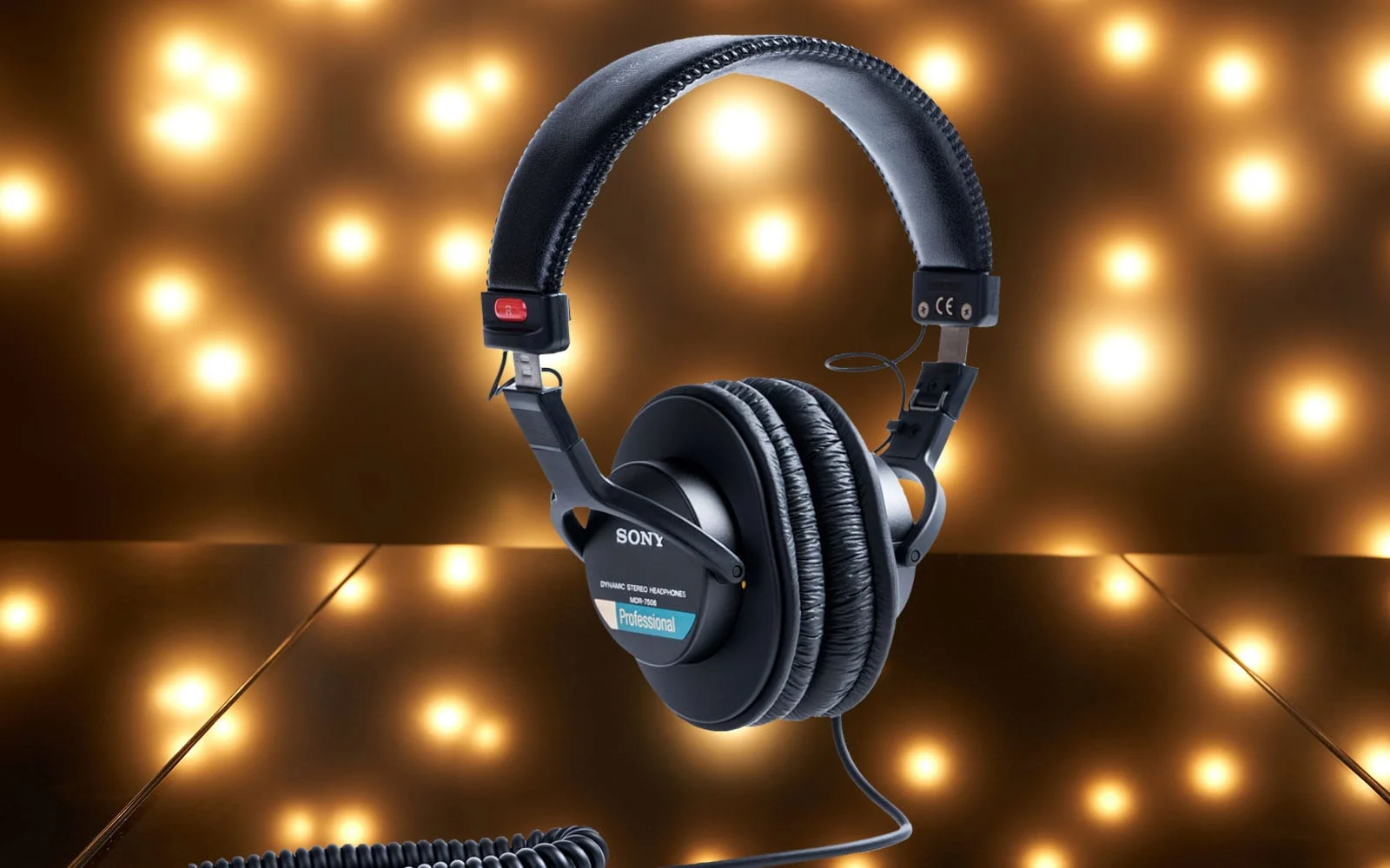 Le casque Sony MDR-7506 suspendu dans les airs devant un fond sombre parsemé de points lumineux brillants.