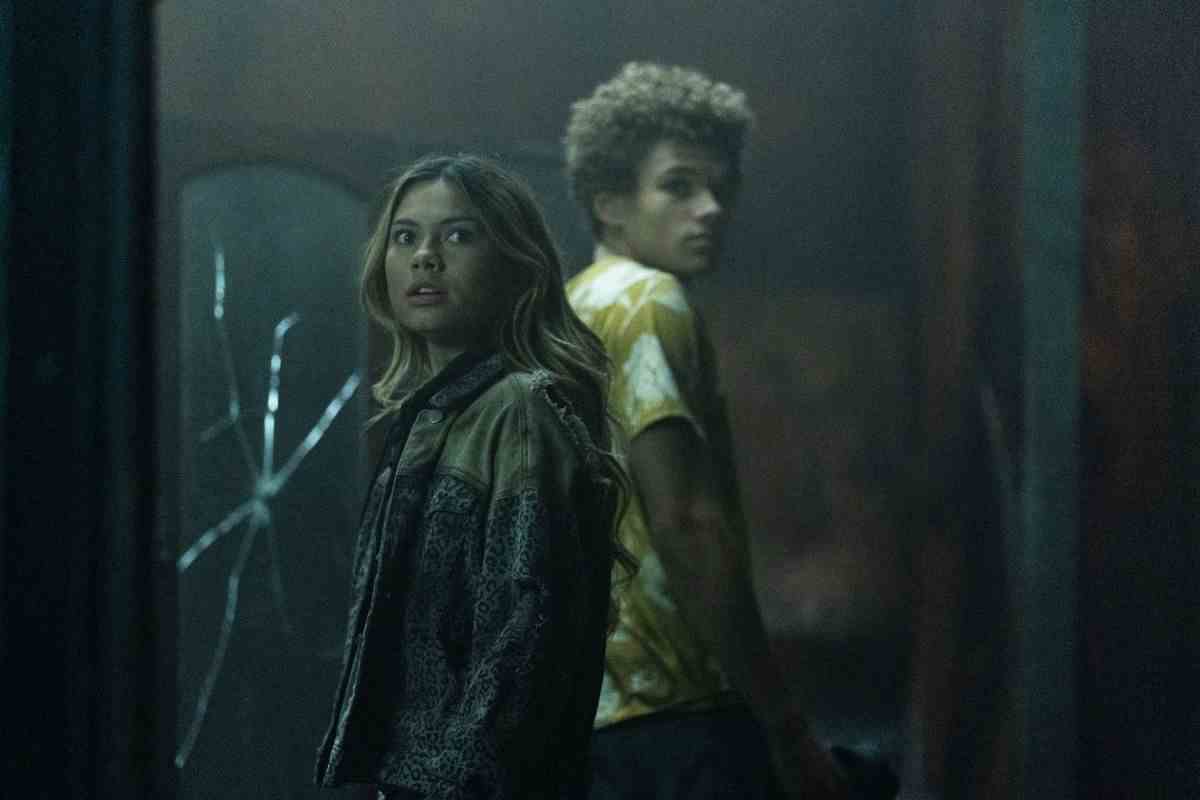 Bella Shepard dans le rôle de Blake Navarro et Armani Jackson dans le rôle d'Everett Lang se tiennent dos à dos devant un miroir fissuré dans une vieille maison poussiéreuse dans The Wolf Pack