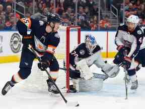 Dylan Holloway (55 ans) des Oilers d'Edmonton cherche une passe devant le gardien Joonas Korpisalo (70 ans) des Blue Jackets de Columbus à Rogers Place à Edmonton le 25 janvier 2023. Photo de Shaughn Butts-Postmedia