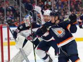 Dylan Holloway (55 ans) des Oilers d'Edmonton tente de dépasser Vladislav Gavrikov (4 ans) des Blue Jackets de Columbus en première période à Rogers Place à Edmonton le 25 janvier 2023. Photo de Shaughn Butts-Postmedia