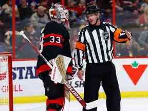 L'arbitre Kevin Pollock explique au gardien de but des Sénateurs d'Ottawa Cam Talbot lors d'un arrêt de jeu pourquoi aucune pénalité n'a été infligée lorsque Talbot a été entravé en deuxième période contre les Islanders de New York au Centre Canadian Tire le mercredi 25 janvier 2023. Talbot est parti le match avec une blessure.