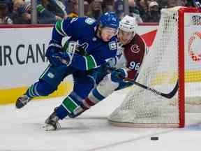 Quinn Hughes, ici pour repousser Mikko Rantanen du Colorado, est encore mieux connu pour son jeu offensif dynamique et sa capacité à déplacer la rondelle sur la glace.