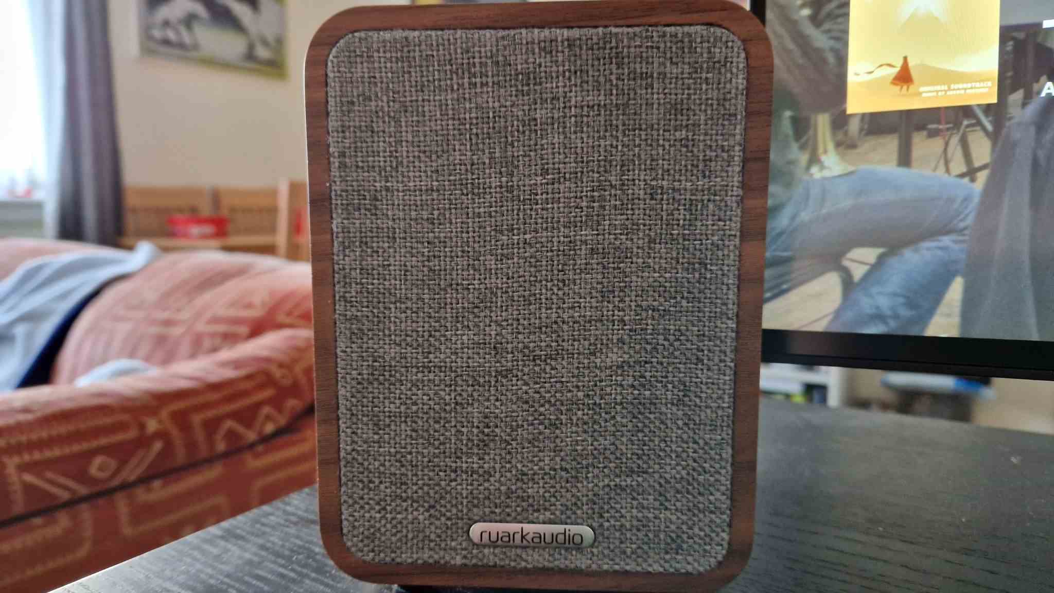 Image d'examen des haut-parleurs Bluetooth Ruark MR1 Mk2 montrant l'avant du haut-parleur gauche et sa grille en maille grise