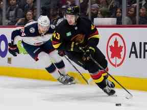 L'attaquant des Blue Jackets de Columbus Mathieu Olivier (24 ans) poursuit le défenseur des Canucks de Vancouver Quinn Hughes (43 ans) en deuxième période au Rogers Arena le 27 janvier 2023.