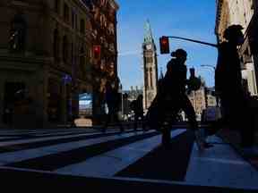 Aujourd'hui, les fonctionnaires fédéraux entament la transition vers le retour au travail en personne.  Des piétons se frayent un chemin le long du centre commercial de la rue Sparks à Ottawa, le 9 novembre 2021.