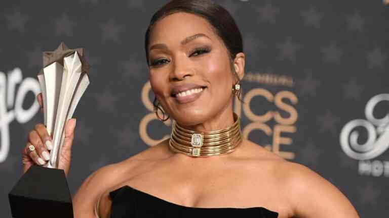 Angela Bassett holding her award in a black dress at the 28th Critics Choice Awards. 