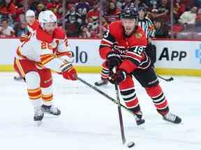 Michael Stone des Flames de Calgary et Jonathan Toews des Blackhawks de Chicago se battent pour le contrôle de la rondelle lors de la deuxième période au United Center le 08 janvier 2023 à Chicago, Illinois.