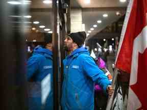 Des manifestants crient à la porte d'un hôtel où séjourne le premier ministre Justin Trudeau pendant la retraite du cabinet libéral, au centre-ville de Hamilton, en Ontario, le 24 janvier 2023.