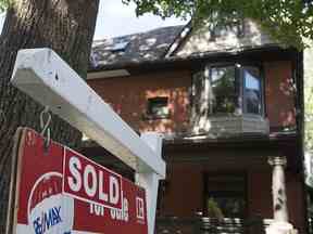 Une maison avec une pancarte à vendre indiquant qu'elle a été vendue comme on le voit à Toronto, le mardi 23 juin 2015.