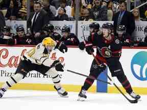 Le défenseur des Sénateurs Thomas Chabot contrôle la rondelle contre l'ailier des Penguins Drew O'Connor lors de la première période au PPG Paints Arena.