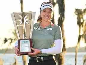 La Canadienne Brooke Henderson pose avec le trophée après avoir remporté le tournoi des champions Hilton Grand Vacations au Lake Nona Golf & Country Club dimanche à Orlando, en Floride.